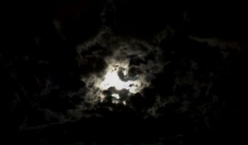 Wolken am Nachthimmel, die im Mondschein die Form eines Einhorns haben