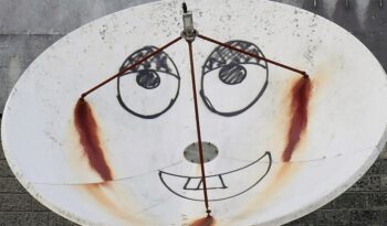 Ein Smiley ist auf eine Satellitenschüssel gemalt.